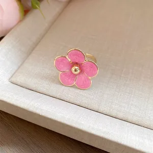 Detalle de un anillo de flor de esmalte rosa con elegante borde dorado en una bandeja