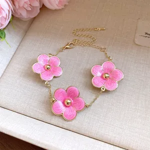 Elegante pulsera con flores de esmalte rosa y una cadena dorada ajustable para mujer