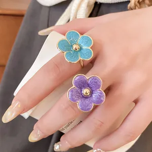 Detalle de cerca que muestra elegantes anillos de flores esmaltados en azul y violeta