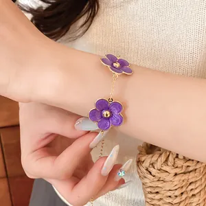 Primer plano detallado de una pulsera con flores moradas en una muñeca femenina elegante