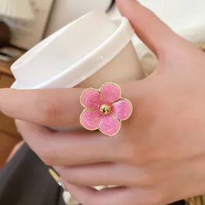 Vista macro detallada de un anillo de flor de esmalte rosa dulce con borde dorado