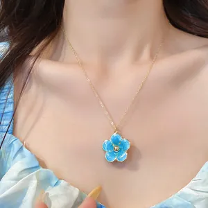 Detalle de cerca de un delicado collar con colgante de flor de esmalte azul usado en el cuello