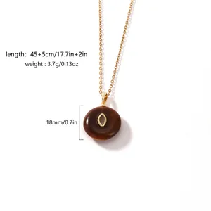 Close-up of vintage brown resin pendant with gold-plated chain and size markings