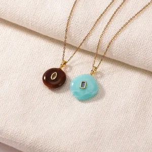 Detail view of colorful resin geometric pendants on gold plated stainless steel chains