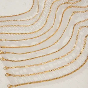 Primer plano de varios estilos de cadenas de acero inoxidable dorado sobre textura blanca