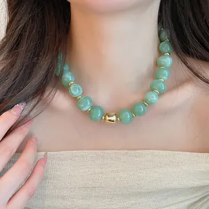 Detail der Sommer-Perlenkette mit hellgrünen Steinen und Goldakzenten am Modell