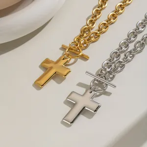 Close-up of gold and silver cross necklaces with OT toggle clasps and shiny metal finish