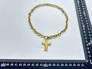 Detailed view of gold stainless steel cross pendant necklace with measurement scale reference.