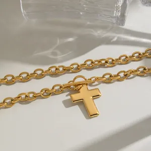 Close-up detail of a gold stainless steel cross pendant necklace with thick links