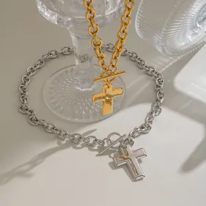 Close-up view of gold and silver stainless steel cross pendant necklaces with OT clasps