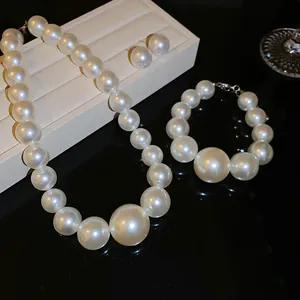 Dettaglio ravvicinato di set gioielli con perle: collana, bracciale e orecchini a lobo