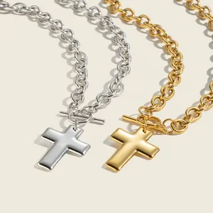Close-up of gold and silver stainless steel cross necklaces with OT buckles.