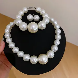 Dettaglio del set di gioielli con perle bianche su un espositore professionale nero