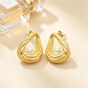 Detailaufnahme von goldene gedrehten Tropfenohrringen aus Edelstahl mit Perlen