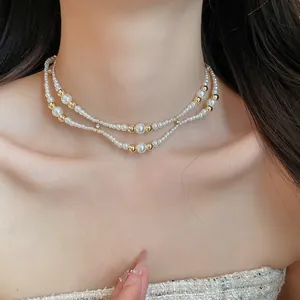 Detail van Franse vintage dubbellaagse parelketting met gouden kralen op de nek