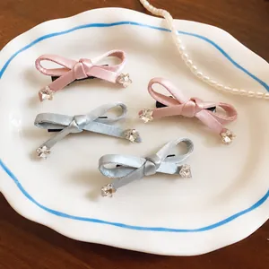 Schattige satijnen strik haarklemmen met sprankelende sterkristallen in roze en blauw