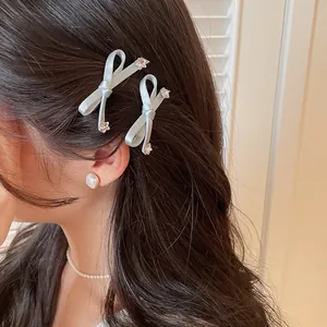 Gros-opname van lichtblauwe satijnen strik haarspeldjes met strass sterbedeltjes