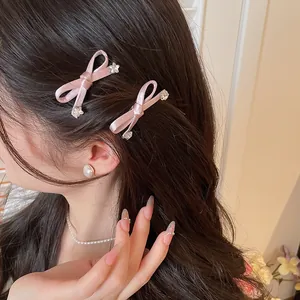 Close-up van schattige roze strik haarspeldjes met kristallen accenten bij een model