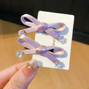 Detailopname van roze strikjes haarclips met fonkelende ster kristal details op kaart.