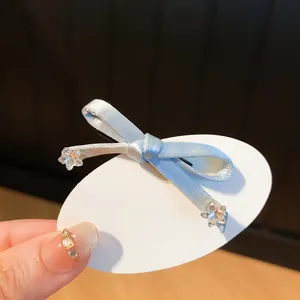 Gedetailleerde weergave van een lichtblauwe haarklem met strik en delicate sterretjes