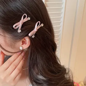 Close-up van elegante roze satijnen strik haarspeldjes met sterretjes in bruin haar