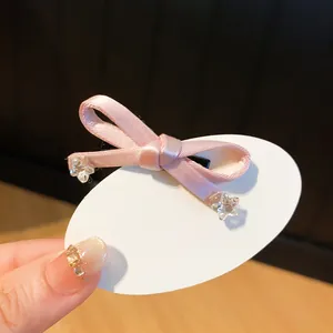 Detailopname van een schattige roze strik haarclip met kristallen sterren.