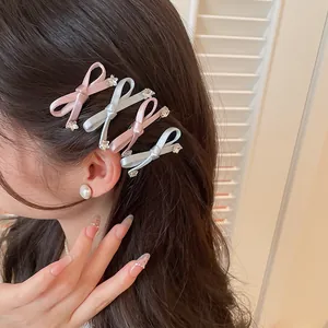 Detailweergave van zoete roze en blauwe strikjes haarclips in het haar van model.