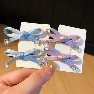 Detailopname van schattige satijnen strik haarspelden met sterrenkristallen op witte kaarten.