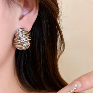 Minimalist retro silver-tone stud earrings with geometric textured dome design worn on ear