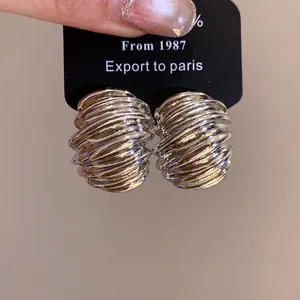 Close-up of vintage silver geometric textured stud earrings on display card