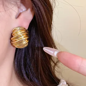 Close-up macro view of vintage gold stud earrings featuring elegant geometric texture design