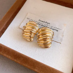 Close-up detail of vintage gold ribbed geometric stud earrings presented in a jewelry box