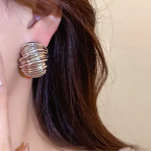 Detailed macro shot of vintage silver geometric textured stud earrings on model's ear