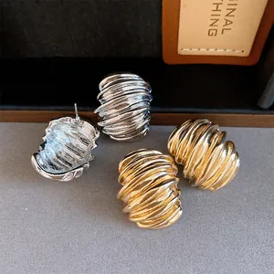 Detail view of vintage geometric textured stud earrings in gold and silver finishes