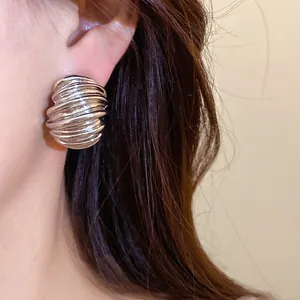 Macro view of vintage silver geometric textured stud earrings worn on an ear for detail