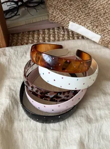 Detailed view of stacked colorful rhinestone headbands with leopard and solid patterns