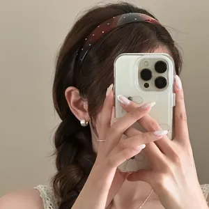 Close-up of a French retro wide headband with colorful rhinestones worn on braided hair.