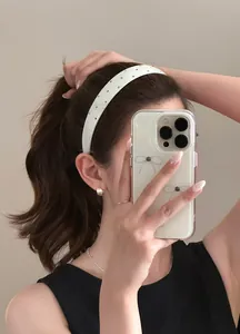 Detailed view of a stylish white wide headband with colorful rhinestones on a female model