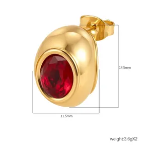 Détail macro d'une boucle d'oreille en acier inoxydable doré 18 carats avec zircon rouge