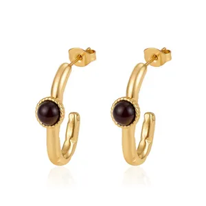Détail de boucles d'oreilles créoles en acier doré 18K avec zircone marron foncé