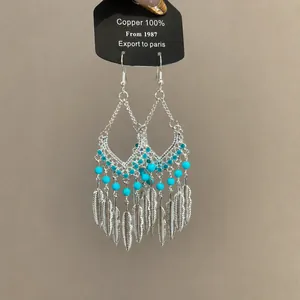Etnische boho oorbellen met veren, turquoise kralen en zilveren metalen kwastjes voor dames
