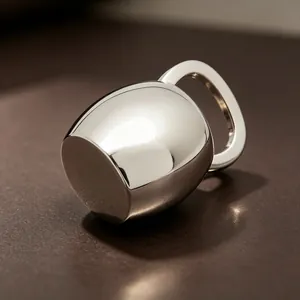 Vue macro détaillée d'un pendentif minimaliste en forme de bouilloire argentée polie