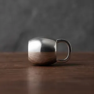 Vue détaillée d'un pendentif bouilloire en argent poli sur une surface en bois