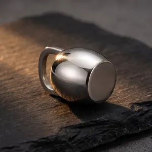 Vue détaillée d'un pendentif bouilloire minimaliste poli sur fond de pierre texturée