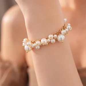 Detailopname van een elegante parelarmband met parels van verschillende groottes in goud.