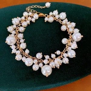 Detailweergave van elegante ketting in paleisstijl met parels van diverse afmetingen en goud.