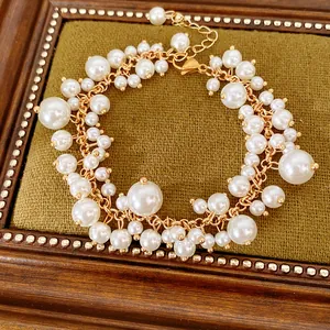 Gedetailleerd overzicht van een elegante goudkleurige armband met witte parels in diverse maten