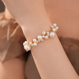 Elegante parelarmband in hofstijl met goudkleurige details om de pols van model