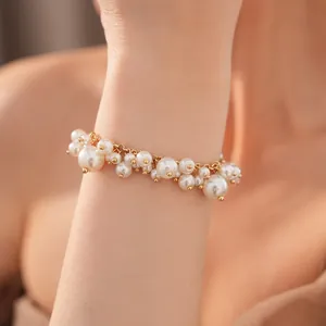 Gedetailleerde weergave van een elegante parelclusterarmband met gouden accenten.