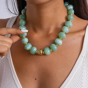 Primo piano di collana vintage in acrilico marmorizzato con cubo geometrico dorato
